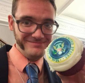 Showing off a red velvet cupcake with the POTUS seal on it at the White House. 